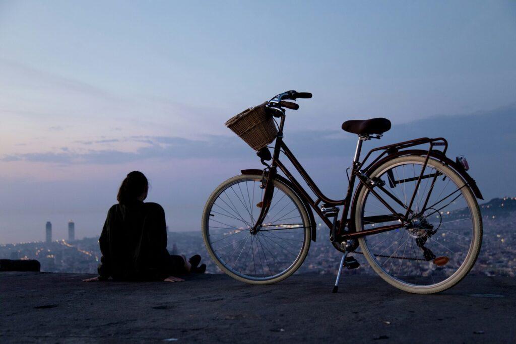 A bicycle parked at a viewpoint overlooking the city at dusk